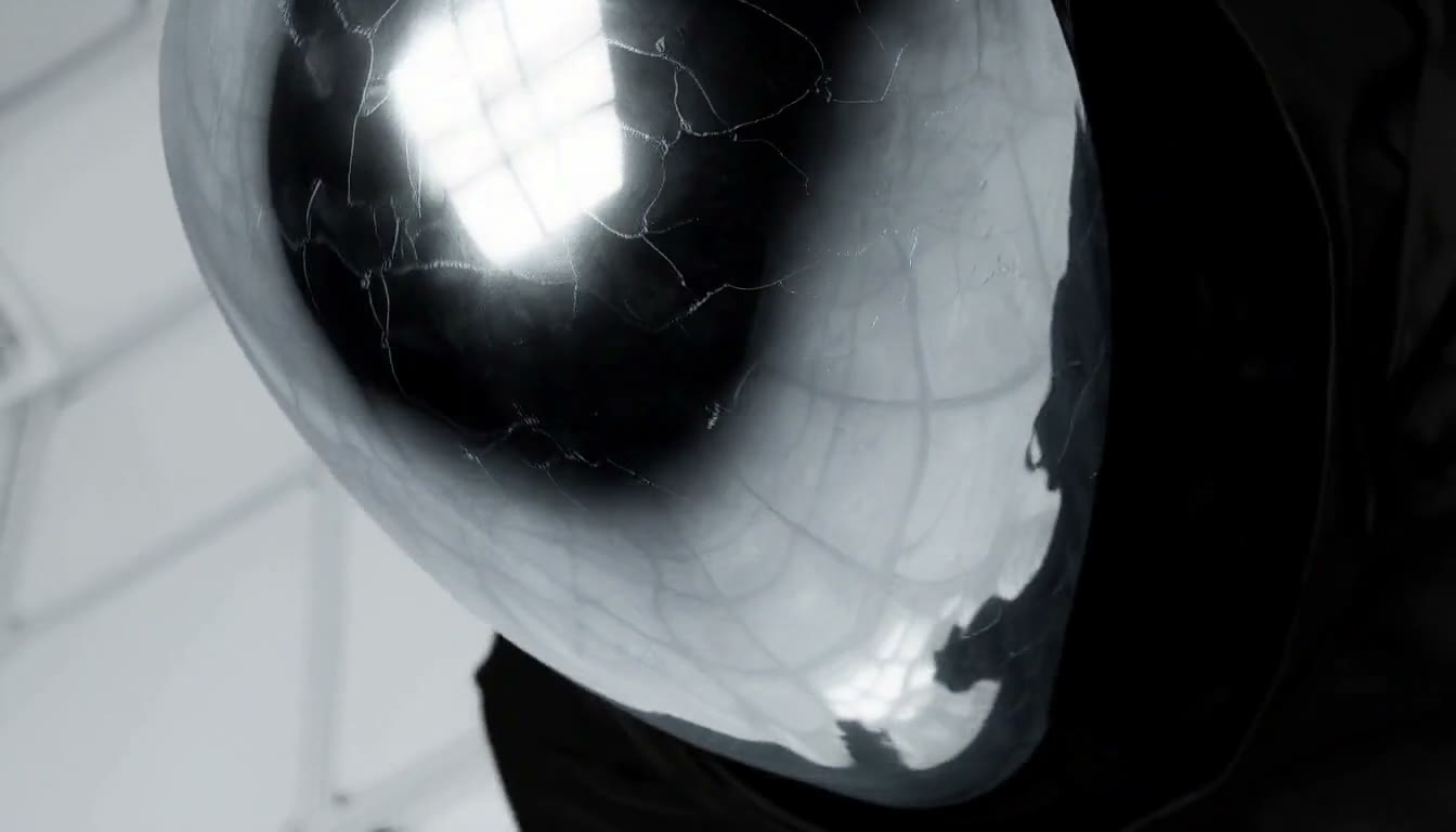 MiniMax H3 AI video example showing a person wearing a futuristic, metallic helmet with a cracked pattern, dressed in a black outfit, is seen in a high-tech environment